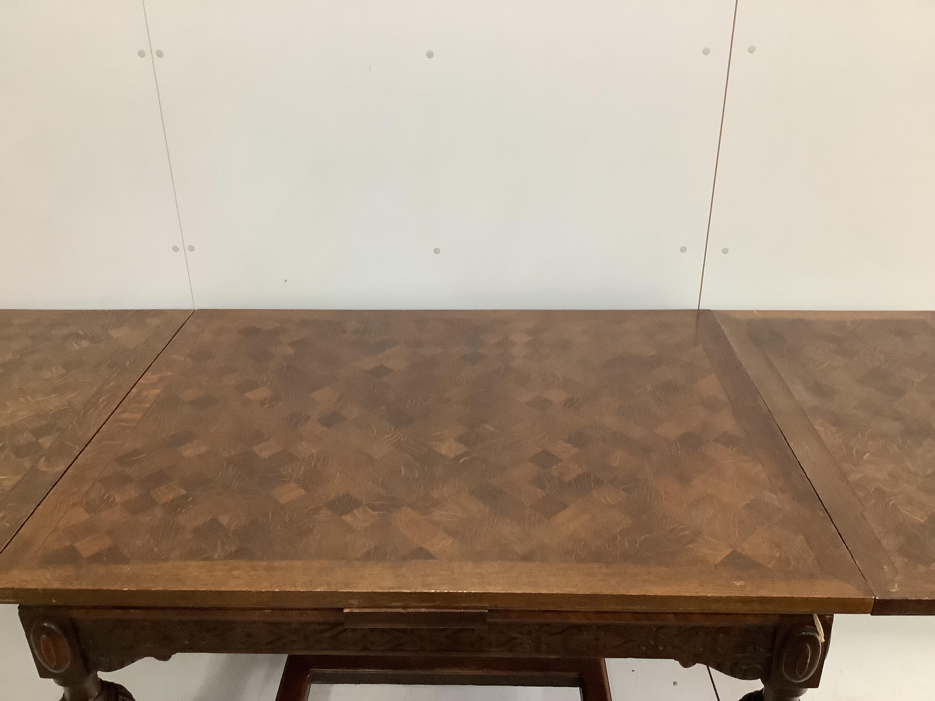 A Jacobean Revival parquetry inlaid rectangular oak draw leaf dining table, 220cm extended, depth 94cm, height 78cm together with six 1920's oak dining chairs, two with arms